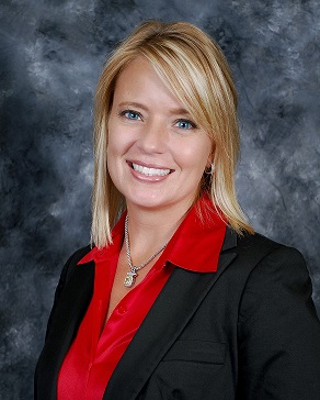 Portrait of a smiling woman in a black suit and red blouse on a black and gray background